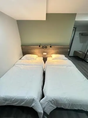 two beds sitting next to each other in a room at EpochHotel in Taiping