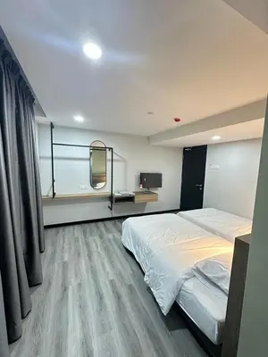 a bedroom with a large bed and a mirror at EpochHotel in Taiping