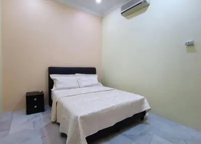 a bedroom with a bed with a white blanket at IPOH Be-Shine TAMAN WANG 13-14pax Homestay with 6Bedrooms, 6Bathroom, 1Living, 1Dining, 1Kitchen with 3Parkings in Ipoh