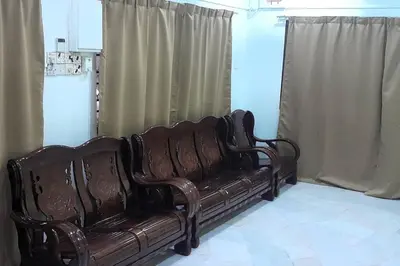 a brown couch sitting in a room with curtains at IPOH Be-Shine TAMAN WANG 13-14pax Homestay with 6Bedrooms, 6Bathroom, 1Living, 1Dining, 1Kitchen with 3Parkings in Ipoh