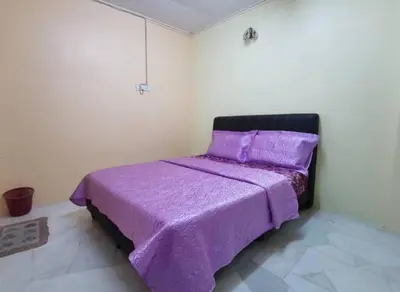 a bed with a purple bedspread in a room at IPOH Be-Shine TAMAN WANG 13-14pax Homestay with 6Bedrooms, 6Bathroom, 1Living, 1Dining, 1Kitchen with 3Parkings in Ipoh