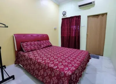 a bedroom with a red bed in a room at IPOH Be-Shine TAMAN WANG 13-14pax Homestay with 6Bedrooms, 6Bathroom, 1Living, 1Dining, 1Kitchen with 3Parkings in Ipoh