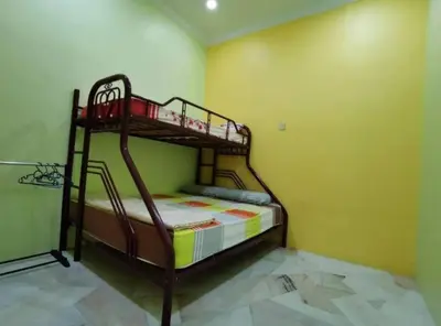 a bedroom with two bunk beds in a yellow wall at IPOH Be-Shine TAMAN WANG 13-14pax Homestay with 6Bedrooms, 6Bathroom, 1Living, 1Dining, 1Kitchen with 3Parkings in Ipoh