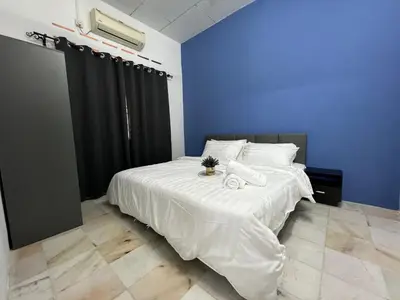 a bedroom with a bed with white sheets and a blue wall at Near 7ELEVE KFC 10pax 3BR Hutan Melintang by willz in Hutan Melintang