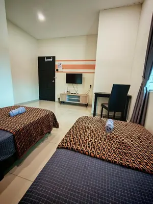 a hotel room with two beds and a television at The Blue Guest House, WiFi, Free Parking, Aulong in Taiping