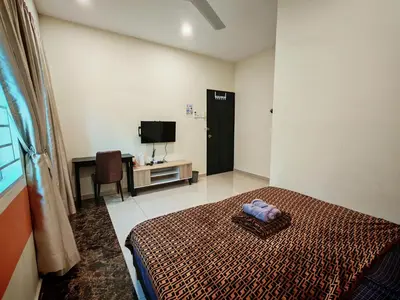 a hotel room with a bed and a television at The Blue Guest House, WiFi, Free Parking, Aulong in Taiping