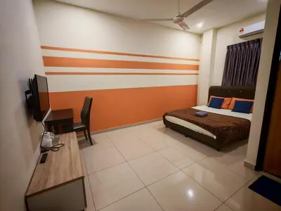 a bedroom with a bed and a desk and a television at The Blue Guest House, WiFi, Free Parking, Aulong in Taiping