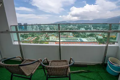 two chairs on a balcony with a view of a city at Georgetown Seaview MansionOne @Penang in George Town