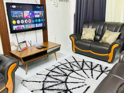 a living room with a couch and a tv at Home in Simpang Ampat in Simpang Ampat