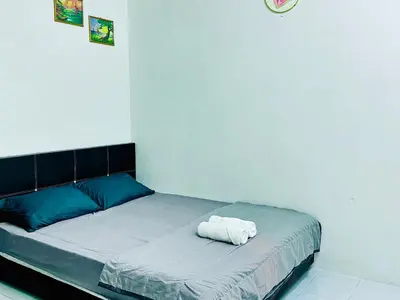 a bed with a white pillow on it in a room at Home in Simpang Ampat in Simpang Ampat
