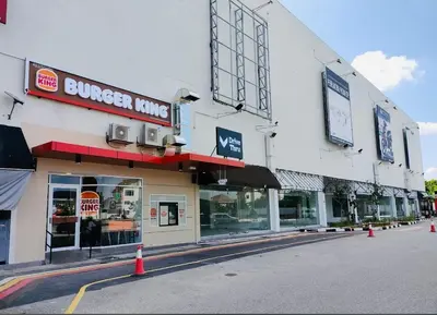 a building with a burger king sign on a street at Home in Simpang Ampat in Simpang Ampat