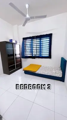 a room with two beds in the corner of a room at HomeSTAY D'Manjung Lumut in Lumut