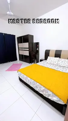 a bedroom with a bed with a yellow blanket at HomeSTAY D'Manjung Lumut in Lumut