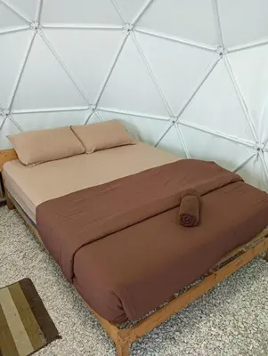 a bed in a room with a wall at Gold Crest Cameron Highlands in Tanah Rata