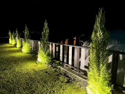 a fence with trees next to a train at night at Gold Crest Cameron Highlands in Tanah Rata