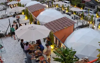 a group of people sitting at tables with umbrellas at Gold Crest Cameron Highlands in Tanah Rata