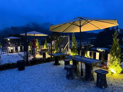 a group of picnic tables and umbrellas at night at Gold Crest Cameron Highlands in Tanah Rata
