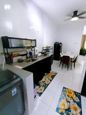 a kitchen with a counter with a sink and a table at HomeSTAY TAMAN MANJUNG POINT LUMUT PERAK in Lumut