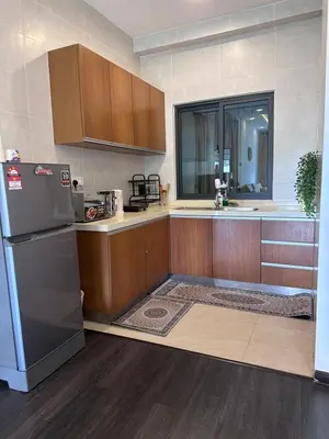 a kitchen with a refrigerator and wooden cabinets at Adamhawa Homestay 2 Nova Cameron Highlands in Brinchang