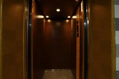 a elevator corridor with a brown wall and a door at Cameron Kea Farm Hotel in Brinchang