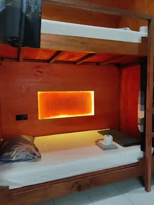 a bed in a bunk bedded room with a desk at Jungle Ippie Hostel in Tanah Rata