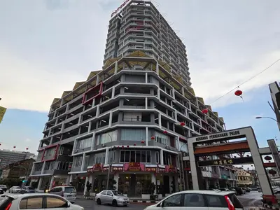 a tall building with cars parked in front of it at The Octagon Ipoh City Centre Leisure Suite in Ipoh