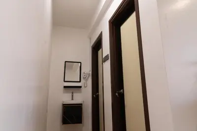 a bathroom with a door and a sink and a mirror at Sunrisestay in Brinchang
