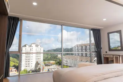 a bedroom with a large window with a view at Sunrisestay in Brinchang