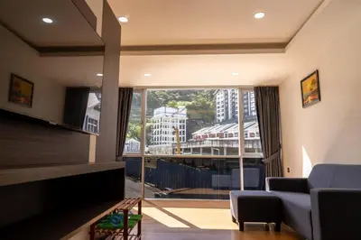 a living room with a couch and a large window at Sunrisestay in Brinchang