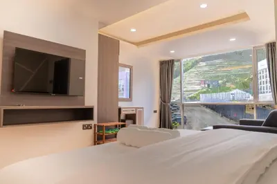 a bedroom with a large bed and a large window at Sunrisestay in Brinchang