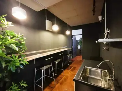 a kitchen with a sink and a bar with stools at 12 George town 6room terrace gurney heritage adventist hospital restaurant shopping mall in George Town
