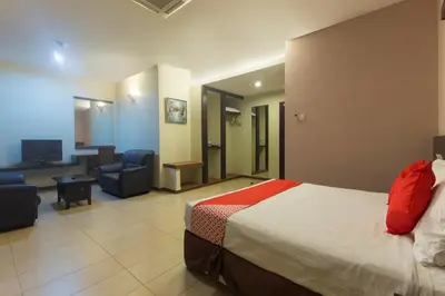 a hotel room with a bed and a living room at Hotel O Bei King in Sitiawan