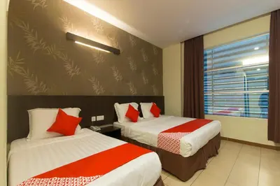 a hotel room with two beds and a window at Hotel O Bei King in Sitiawan