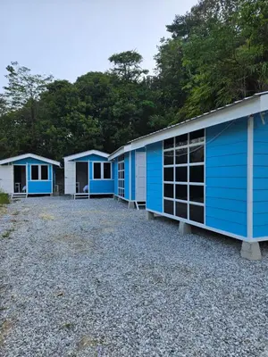 a row of blue buildings sitting on top of gravel at Sentosa Palace in Dabung