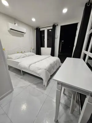 a white bedroom with a bed and a table at Sentosa Palace in Dabung