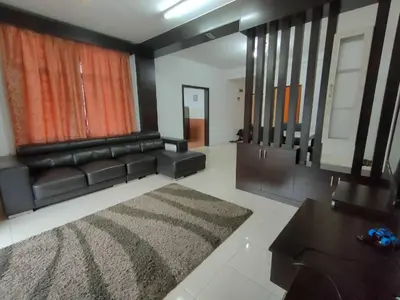 a living room with a black leather couch and a rug at Centrum Homestay in Cameron Highlands