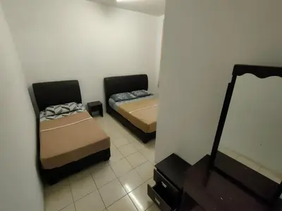 a small room with two beds and a mirror at Centrum Homestay in Cameron Highlands