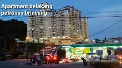 a gas station at night with a tall building at Centrum Homestay in Cameron Highlands