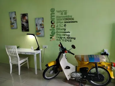 a motorcycle parked next to a desk with a lamp at Idea Homestay 1 in Chemor