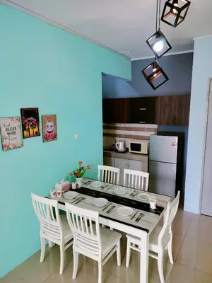a dining room with a table and white chairs at Idea Homestay 1 in Chemor