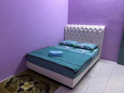 a bed in a room with a purple wall at MyLittle Homestay in Tanjung Malim