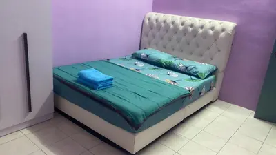 a small bed in a room with a purple wall at MyLittle Homestay in Tanjung Malim