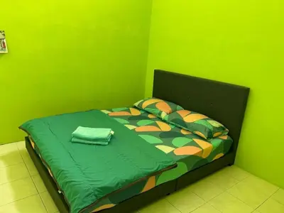 a green bedroom with a bed with a green wall at MyLittle Homestay in Tanjung Malim