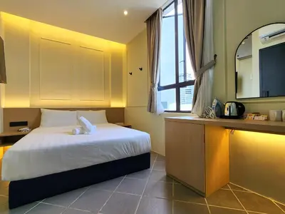 a bedroom with a bed and a sink and a mirror at Georgetown AY Hotel in George Town