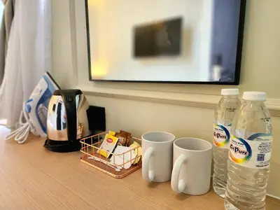a table with two cups and two bottles of water at Georgetown AY Hotel in George Town