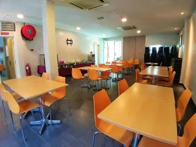 a restaurant with tables and chairs in a room at Hotel Jelai @ Raub, Pahang in Raub