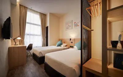 a hotel room with two beds and a window at U Hotel Penang in Bayan Lepas