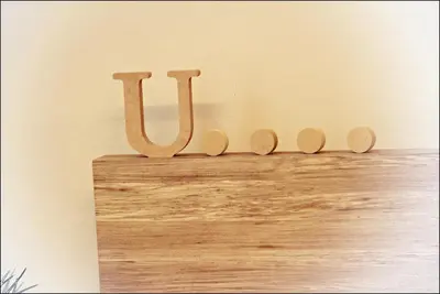 a wooden sign that says ux on a wall at U Hotel Penang in Bayan Lepas