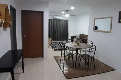 a dining room and living room with a table and chairs at 3R Guest House Manhattan Condominium in Ipoh