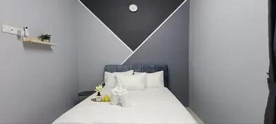 a bedroom with a bed with white sheets and white pillows at Ipoh Garden East Homestay by Grab A Stay in Ipoh